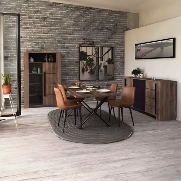 Comedor moderno con mesa redonda madera y sillas tapizadas caramelo junto a muebles de almacenamiento en madera y pared de ladri