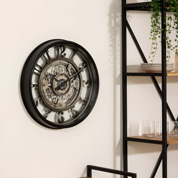 Reloj de pared redondo marco negro con mecanismo engranajes visible y números romanos