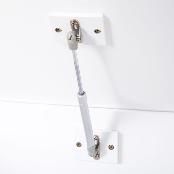 Tirador de mueble blanco con tubo metálico y soportes de fijación de latón instalado en el baúl