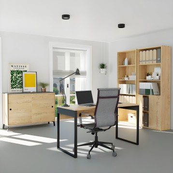 Ambiente de oficina en casa con escritorio madera y estructura negra y silla de oficina gris con respaldo alto junto a estanterí