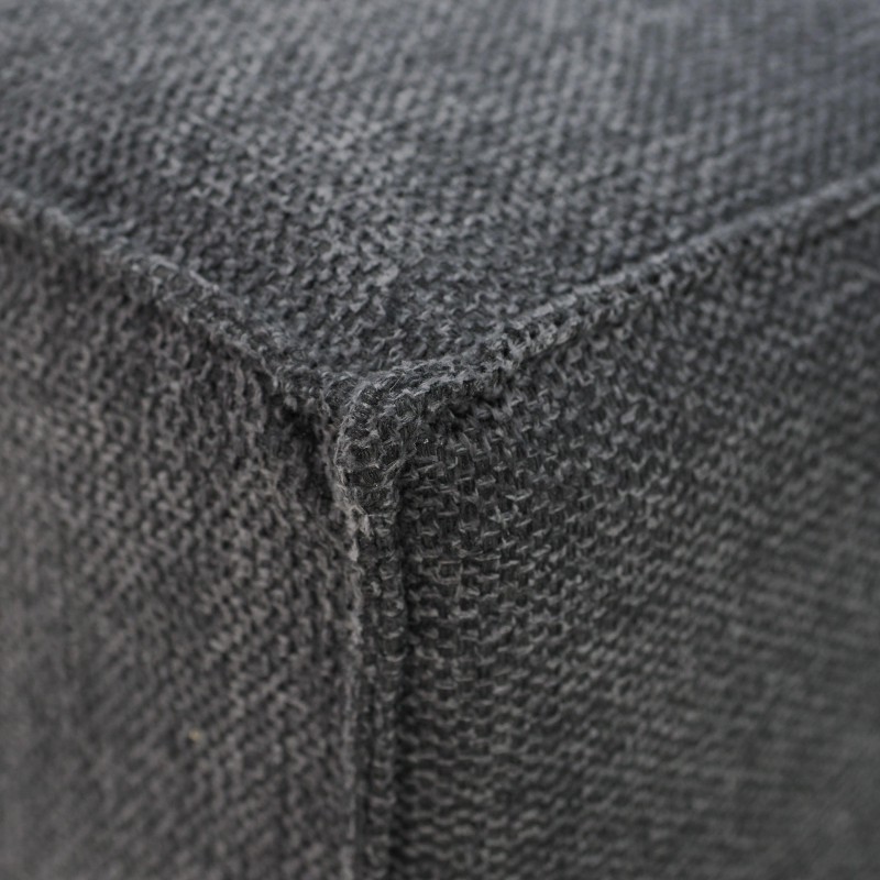 Detalle de tapizado gris oscuro con textura de tejido y costura en esquina