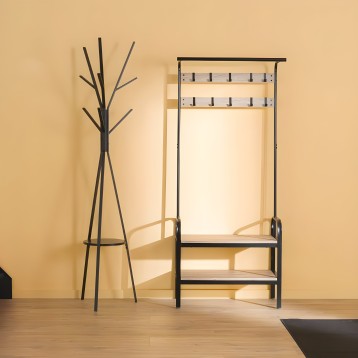 Perchero árbol negro con base circular y espejo de pared con marco negro y madera natural en ambiente