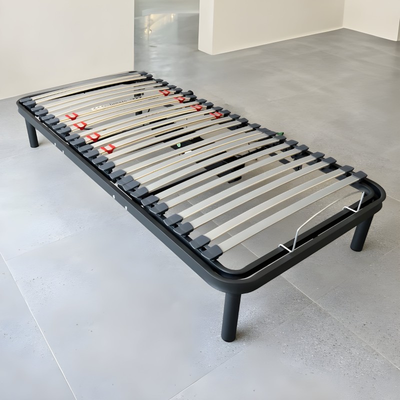 Somier con estructura negra y láminas de madera con soportes rojos en ambiente de showroom