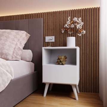 Mesita de noche blanca con estante abierto y cajón junto a cama con cabecero gris en dormitorio