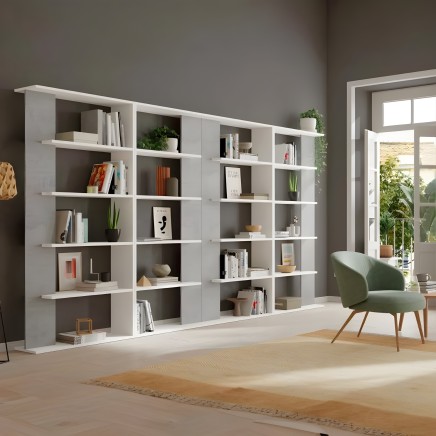 Estantería modular blanca de múltiples compartimentos con libros plantas y objetos decorativos en ambiente de sala