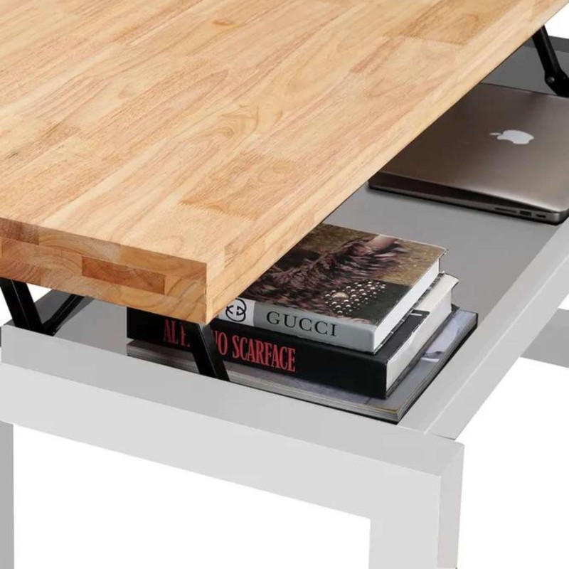 Mesa de centro con tablero de madera clara y base blanca con cajón abierto que contiene libros y laptop