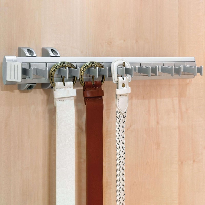 Perchero de pared gris con raíl y ganchos decorativos sosteniendo cinturones blancos y marrones