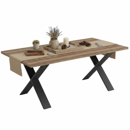 Mesa de comedor de madera natural con patas en X negras y decoración de plantas y accesorios