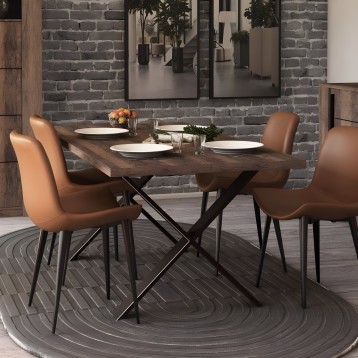 Comedor con mesa de madera oscura y patas cruzadas negras acompañada de cuatro sillas tapizadas en cuero marrón claro y patas ne