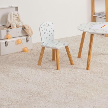 Silla infantil blanca con estampado de estrellas y luna patas de madera en habitación infantil