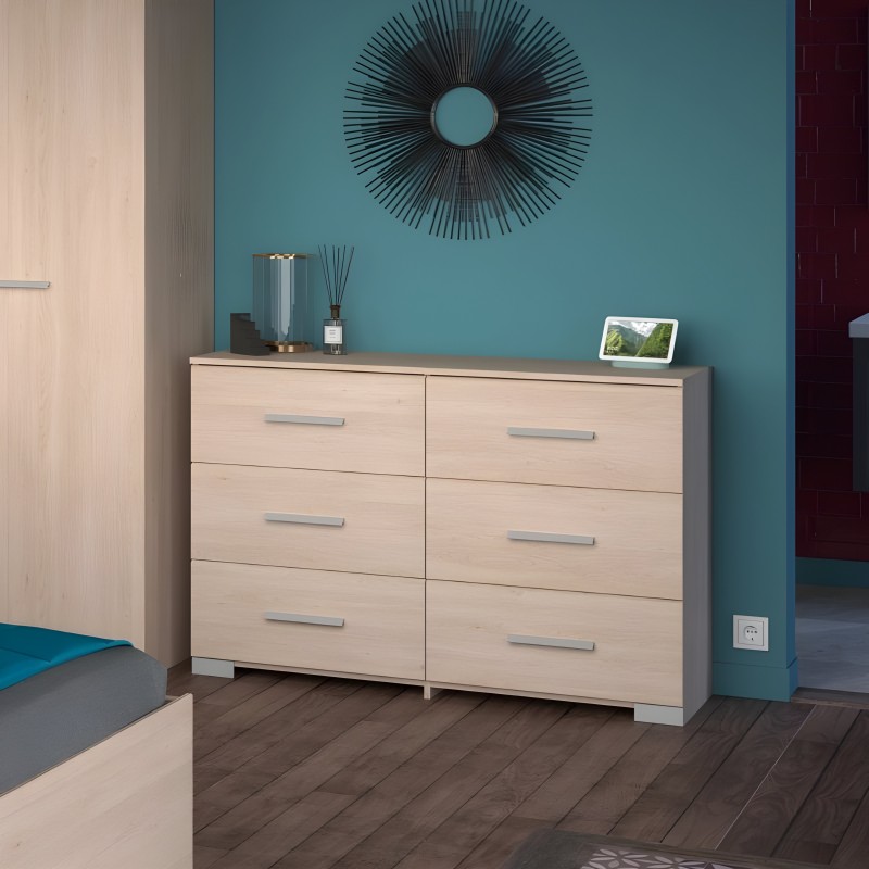 Cómoda de madera clara con seis cajones y tiradores metálicos en dormitorio con pared azul turquesa
