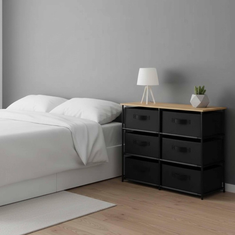 Mesita de noche negra con tapa de madera y seis cajones junto a cama blanca en ambiente de dormitorio