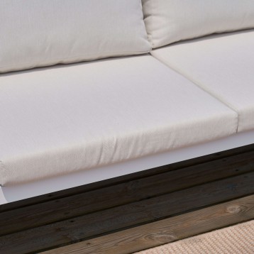 Sofá en tela blanca cruda con cojines y estructura de madera oscura detalle de asiento y respaldo