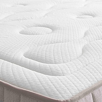 Detalle de colchón blanco acolchado con superficie ergonómica y costuras en patrón geométrico