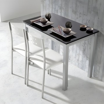 Mesa alta de comedor con tablero negro y estructura blanca acompañada de dos sillas altas blancas en ambiente minimalista