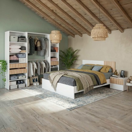 Dormitorio moderno con cama blanca y madera natural rodeado de armario abierto con textiles y ropa