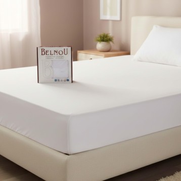 Sábana bajera blanca de algodón sobre cama con packaging Belnou en dormitorio luminoso