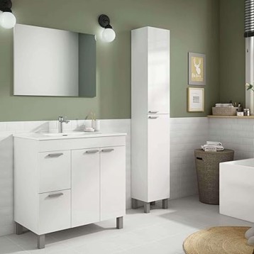 Ambiente de baño moderno con mueble blanco bajo lavabo y columna almacenaje blanca en espacio con paredes verde salvia y blanco