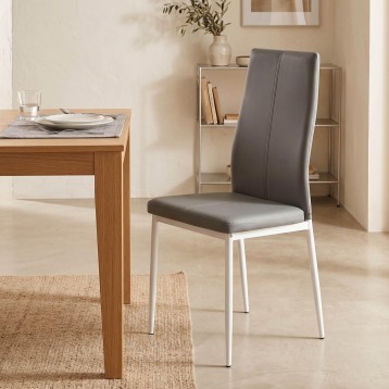 Silla de comedor con respaldo alto tapizado en gris oscuro y estructura metálica blanca junto a mesa de madera en ambiente de co