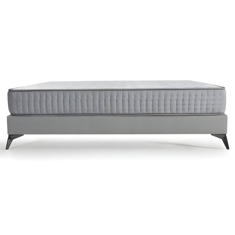Cama con somier tapizado gris y colchón acolchado blanco patas de madera negra vista lateral