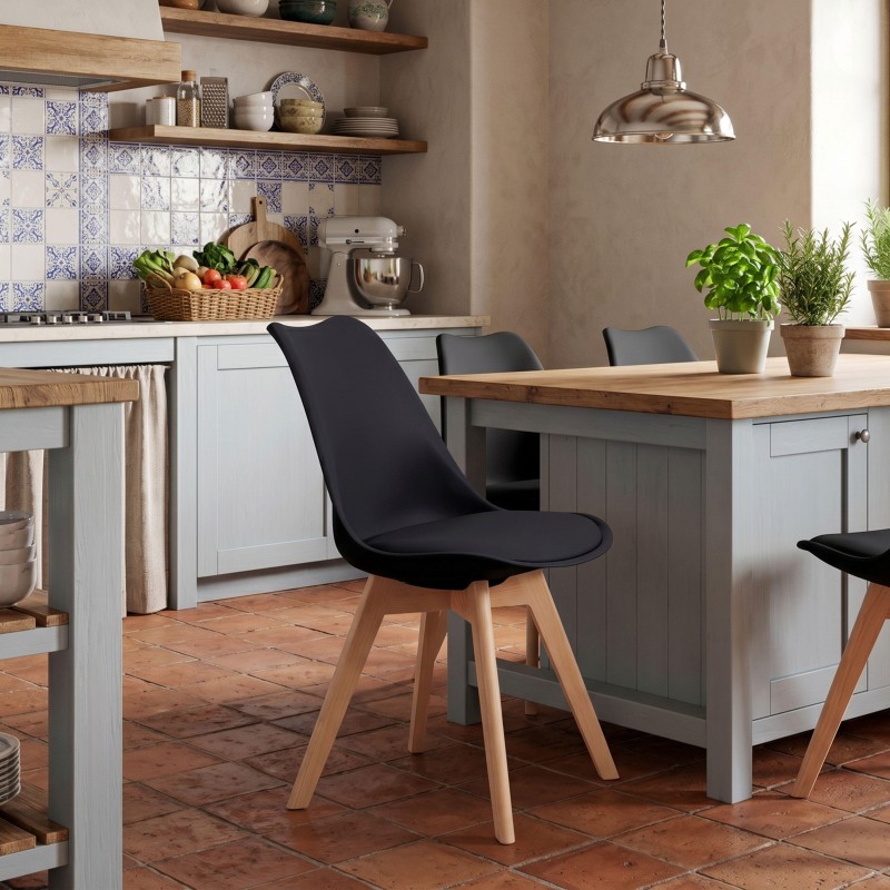 Silla de comedor con asiento negro y patas de madera clara en cocina de estilo nórdico