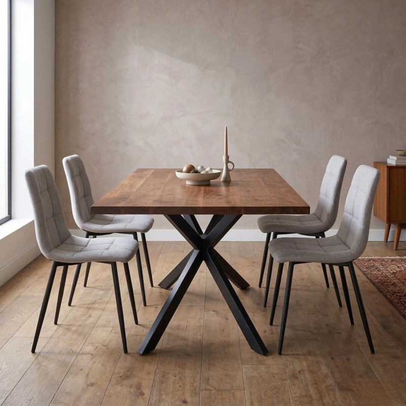 Comedor con mesa de madera y base negra en X acompañada de cuatro sillas tapizadas en gris claro y patas metálicas