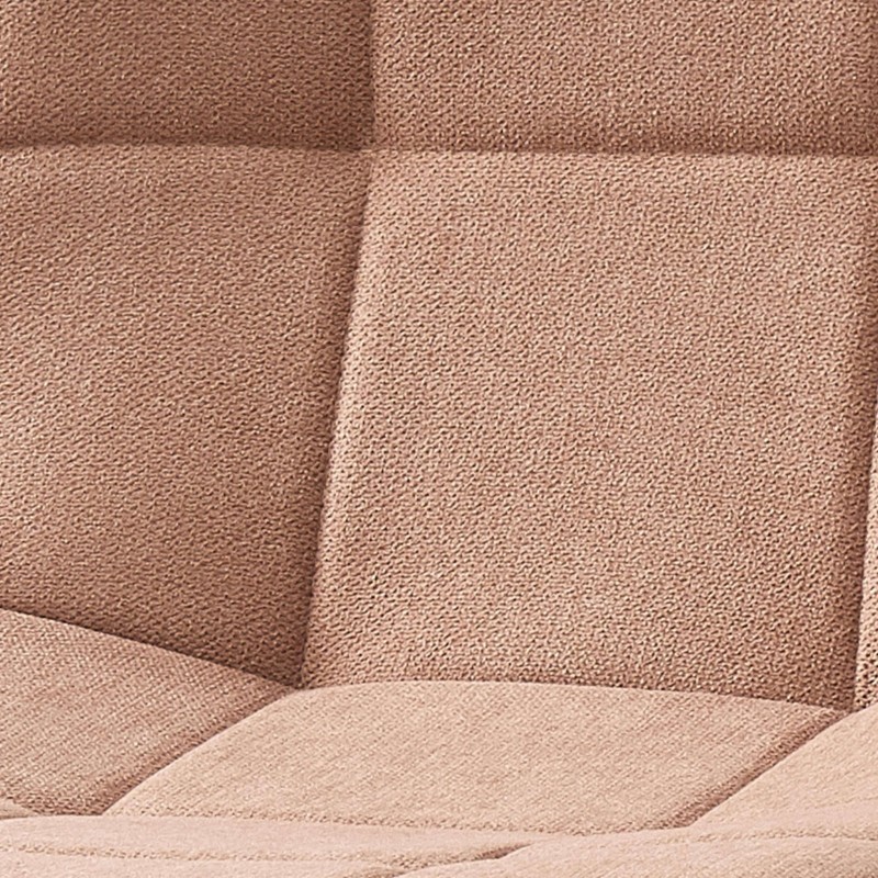 Detalle de cojín de sofá en tela beige texturizada con costuras y relleno acolchado
