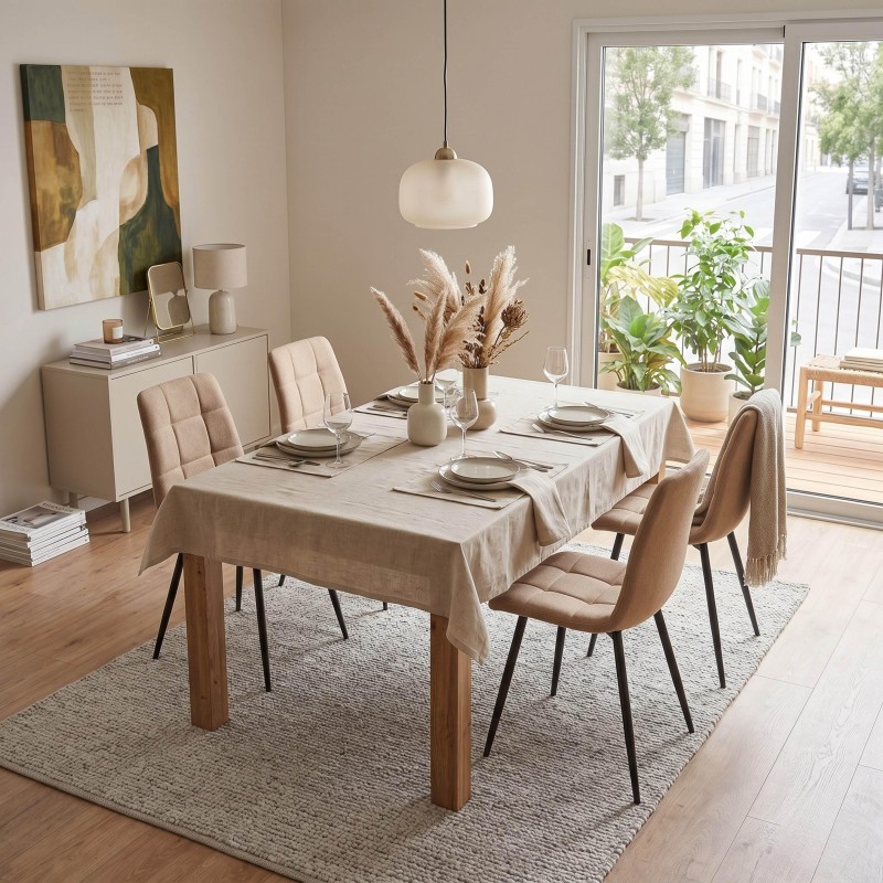 Comedor con mesa de madera clara y mantel beige y sillas tapizadas en tonos naturales en ambiente luminoso