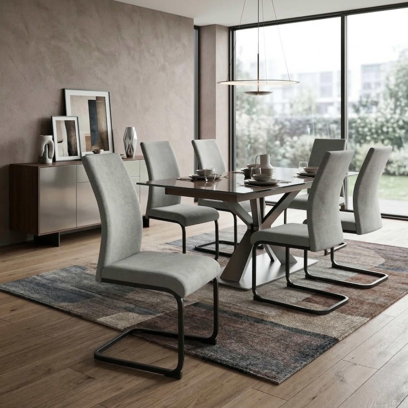 Comedor moderno con mesa negra y sillas grises tapizadas en ambiente de vivienda junto a ventanal