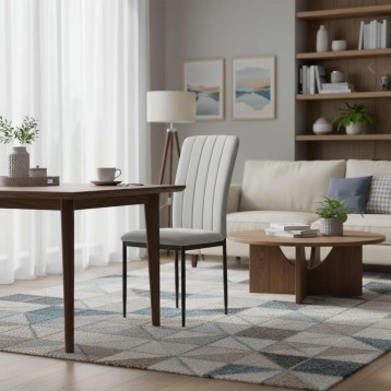 Silla de comedor con respaldo acolchado gris claro y patas metálicas negras en ambiente de sala moderna