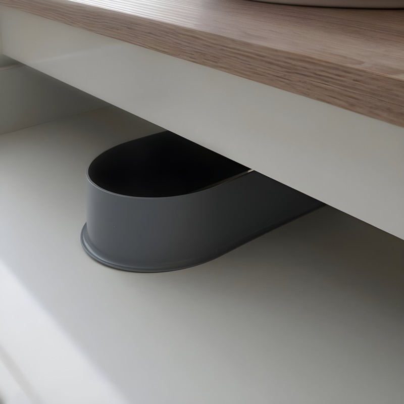 Tirador de mueble ovalado negro integrado en cajón blanco bajo encimera de madera clara