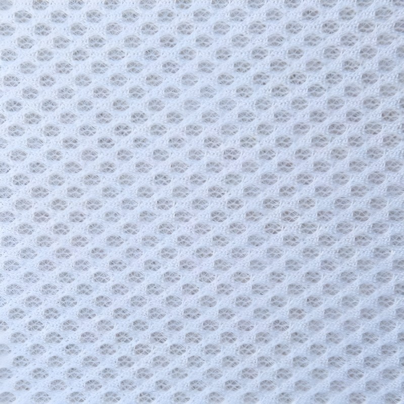 Detalle de tela blanca con textura de tejido acolchado y patrón de cuadrícula en relieve