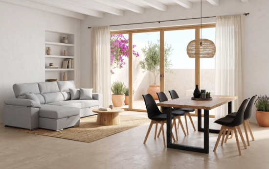 Sofá chaise longue gris con arcón y mesa de comedor de madera con sillas negras en salón comedor mediterráneo