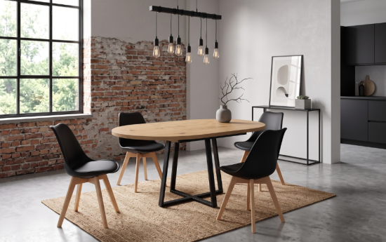Mesa de comedor ovalada de madera con sillas negras en salón de estilo industrial
