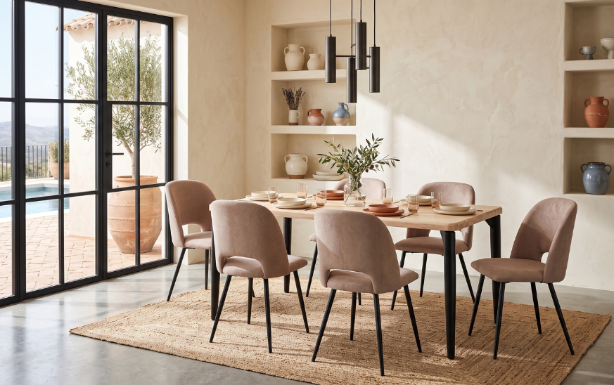 Mesa de comedor de madera con seis sillas tapizadas en beige en comedor de estilo mediterráneo