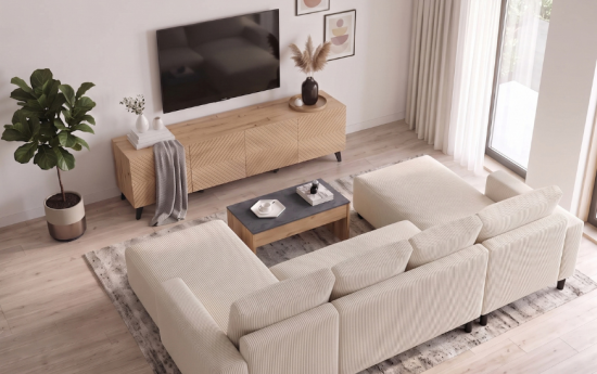 Sofá rinconero de pana beige frente al mueble de televisión en un salón moderno