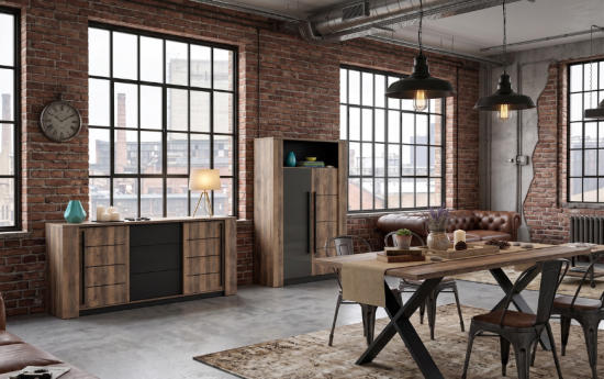 Un salón de estilo industrial con paredes de ladrillo visto y grandes ventanales. Incluye los tres muebles de madera rústica y metal negro (aparador, vitrina y mesa de comedor con patas en X) decorados exactamente con los mismos jarrones, lámpara y detalles de las imágenes.